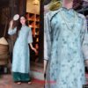 Áo dài hoa nhí màu xanh dương phong cách vintage, thiết kế dáng suông nhẹ, hoạ tiết hoa nhí tươi tắn, viền xanh dương đậm ở cổ và tay áo, phù hợp cho tiệc tùng và sự kiện
